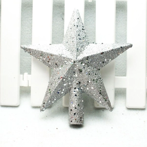 Detailed view of silver glitter star tree topper leaning against a white fence decoration