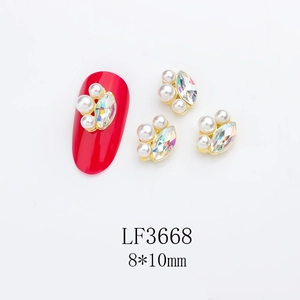 Macro view of a 8x10mm marquise rhinestone and pearl nail charm with gold metal frame