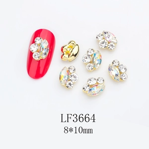 Detailed view of 8x10mm cat paw nail art charms with golden base and sparkling crystals