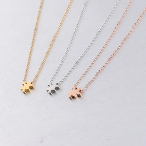 Three jigsaw puzzle piece pendant necklaces in gold, silver, and rose gold stainless steel