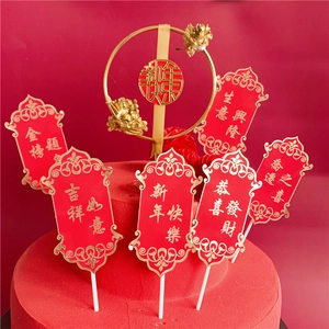 Close-up of gold festive cake toppers with red berry accents and Chinese blessings
