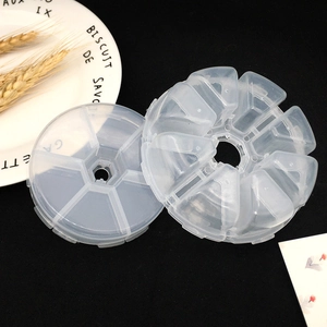 Macro detail of a clear 8-compartment round plastic storage box for jewelry parts