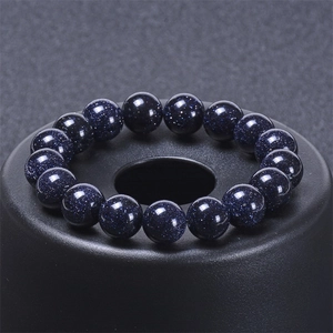 Macro shot of natural blue goldstone beads with galaxy shimmer on a sleek black stand