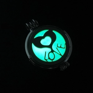 Detailed macro of a luminous hollow heart locket pendant with green glow-in-the-dark center