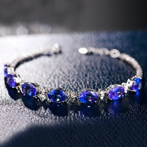Macro shot of silver bracelet with oval-cut blue tanzanite and sparkling side stones