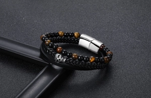 Detail of punk leather bracelet with skull charm, tiger eye stones and magnetic steel clasp
