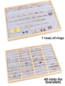 Detail view of wood jewelry tray with grey velvet inserts for rings and bracelets