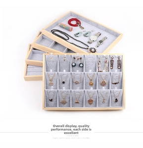 Stack of wooden jewelry trays with grey velvet lining showing necklace boards and slots