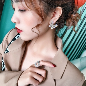 Elegant butterfly zircon earrings and matching ring set worn by model in chic outfit