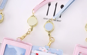 Detail of retractable PU leather card holder with gold hardware in pink and sky blue colors