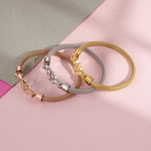 Three steel wire mesh bracelets with clover charms in rose gold, silver, and gold finish