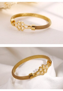 Detail of gold four-leaf clover bracelet with fine woven mesh metal band and openwork