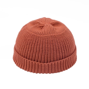 Detail of rust red knit docker hat showing thick ribbed texture and neat top stitching