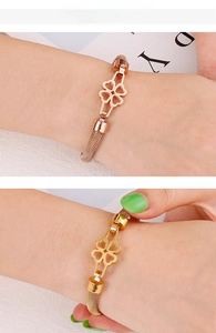 Detailed mesh weave gold and rose gold clover bracelets shown on a model's wrist
