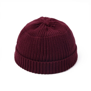 Close-up of burgundy knit beanie showing vertical ribbing texture and rolled edge