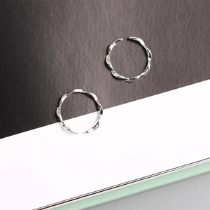 Close-up of polished S925 sterling silver Mobius twisted rings on a modern background