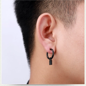 Close-up of black stainless steel hoop earring with industrial spring pendant on ear