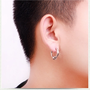 Close-up of minimalist silver hoop earring with three decorative rings on male ear