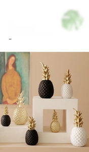 Close-up of modern pineapple ornaments in black, white and gold with textured patterns