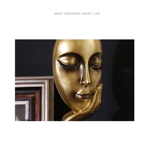 Macro detail of matte gold resin thinker sculpture with abstract facial features