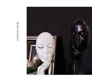 Detailed view of modern resin face sculptures in black and white matte finishes