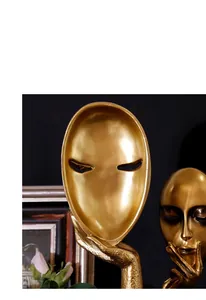 Detailopname van gouden abstract gezichtssculptuur met artistiek hand-tot-masker detail