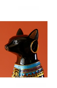 Close-up of Egyptian Bastet cat statue with golden earrings and Eye of Horus neck pattern