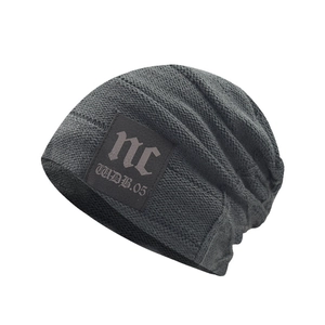 Detail of dark grey knit beanie showing high-quality texture and square patch design