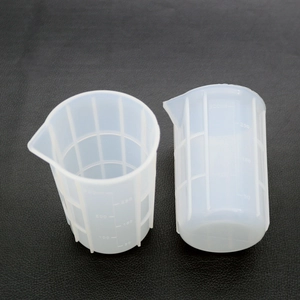 Macro shot of 300ml silicone measuring cups with clear scale markings and pour spouts