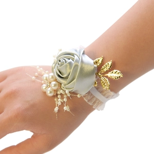 Detail of silver satin rose bridesmaid wrist corsage with pearls and lace on model wrist