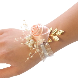 Elegant pink satin rose bridal wrist corsage with pearls and gold leaf on white lace band