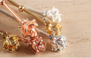 Macro detail of rose-shaped cigarette rings in gold, silver and rose gold metal finishes