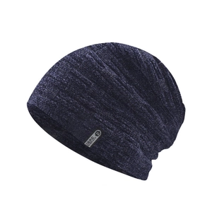 Detail of navy blue chenille knitted beanie showing thick velvet texture and brand tag
