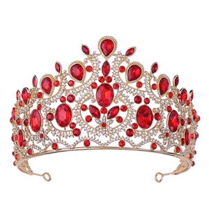 Golden Baroque bridal crown with red gemstones and sparkling rhinestones on white background