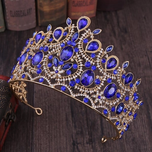 Detailed side view of baroque gold crown with blue rhinestones and intricate metalwork