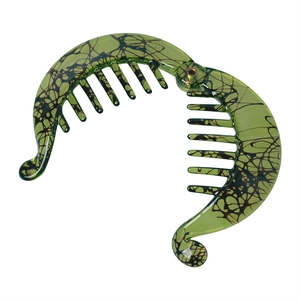 Detail view of emerald green resin banana hair clip with black marble pattern and comb teeth