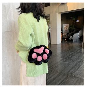 Detailed view of 3D plush cat paw crossbody bag with golden chain strap on model