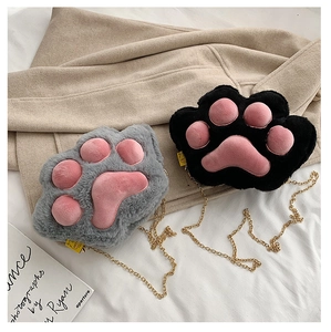 Close-up of soft plush cat paw crossbody bag in black and grey with gold chains