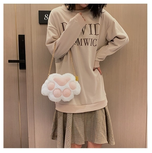 Detailed view of the plush 3D cat paw shoulder bag with golden metal chain strap