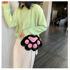 Detail showing the 3D plush cat paw bag with black fur, pink pads, and golden chain strap