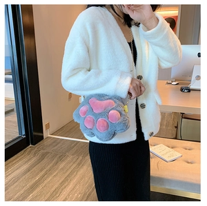 Detail of grey plush cat paw crossbody bag with pink pads and gold metal chain strap