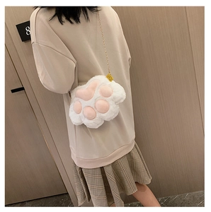 Rear view of a white plush cat paw crossbody bag with pink pads and a metal chain strap