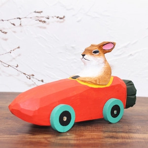 Lapin en bois artisanal conduisant une voiture de course carotte orange décorative
