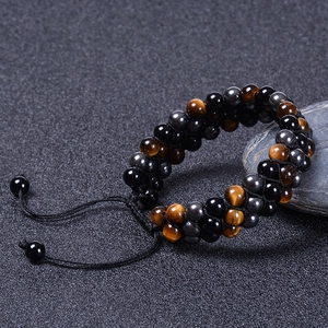 Detailed close-up of triple-row woven bracelet with tiger eye and obsidian natural stones