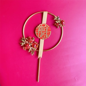 Detail of a golden metal New Year cake topper with red berries and Chinese lettering