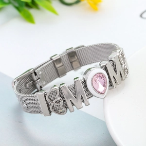 Macro detail of silver mesh bracelet with MOM letters and pink teardrop rhinestone