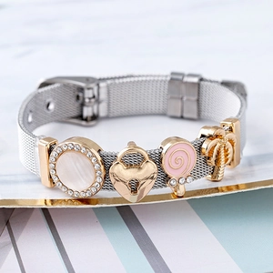 Mesh stainless steel bracelet with golden coconut tree and heart charms on marble