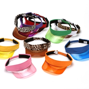 Dettaglio di visiere parasole in PVC trasparente colorato con vari motivi e tonalità neon vivaci