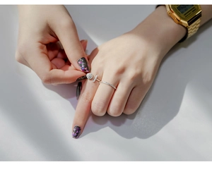 Detailed view of silver T-shaped zircon ring and textured band worn on hand
