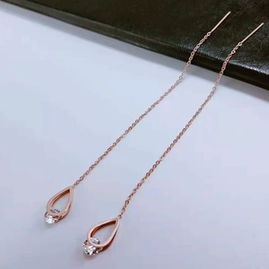 Close-up of rose gold waterdrop tassel earrings with crystal stone on a clean background